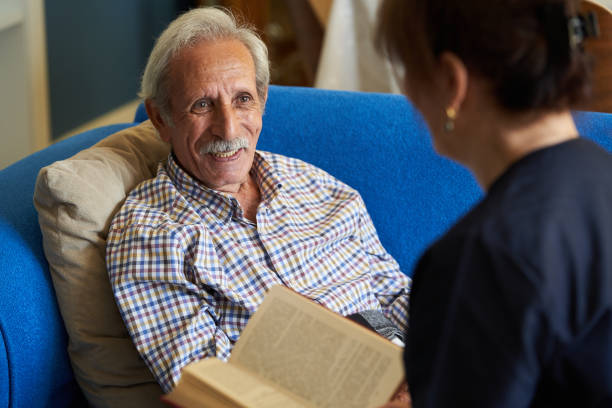 istock Professional helpful caregiver and a senior man during home visit 1185758981