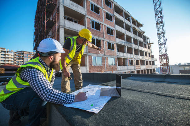architects reviewing blueprints on construction site. - laptop partnership looking communication imagens e fotografias de stock