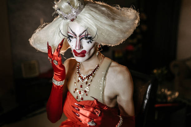 istock Man with blond wig in red dress with bizarre make up 1185762088