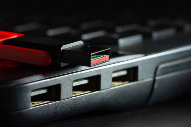 Flash drive in USB port of computer notebook in darkness.