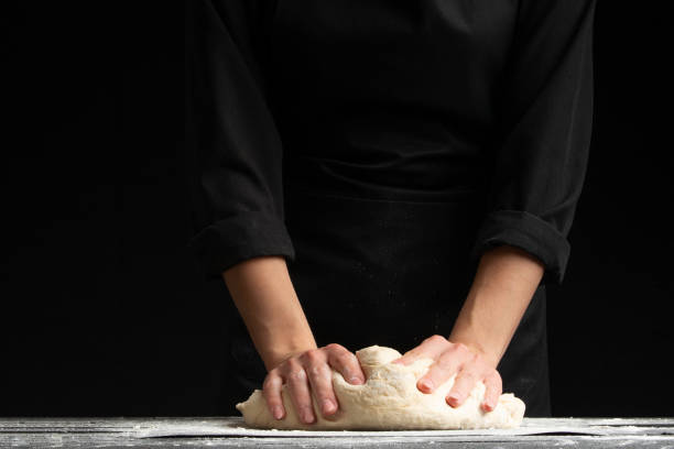 istock Chef works with dough and flour on a dark background 1185766277