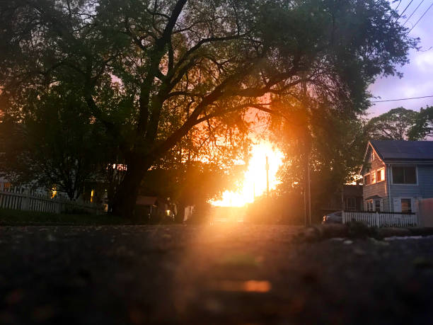 A low angled shot of a suburban street as the sun sets casting a glowing orange color.