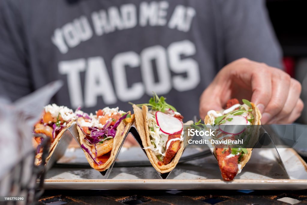 person eating tacos closeup of man eating tacos outside in summer Taco Stock Photo