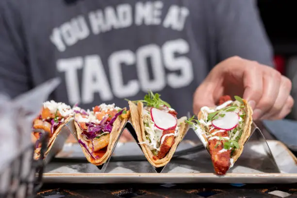 closeup of man eating tacos outside in summer