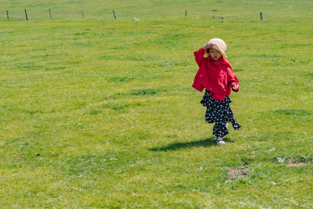 a young girl running on the grass