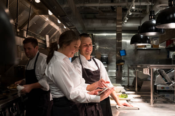 Female restaurant manager discusses menu with chef