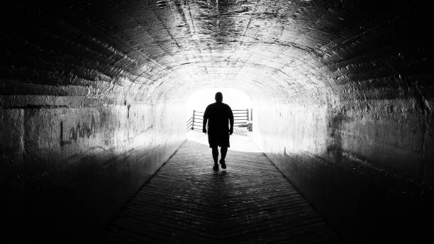 istock silhouette walking in tunnel 1185776227