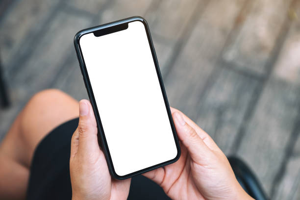 istock a woman holding a black mobile phone with blank white desktop screen 1185778256