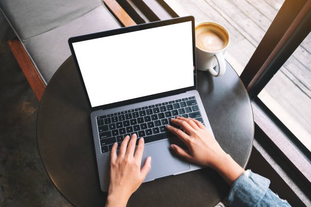 istock a woman using and typing on laptop with blank white desktop screen with coffee cup on the table 1185778294