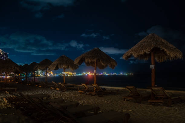 istock Cancun - Mexico - Pool Chairs overlooking the Ocean at night 1185778327