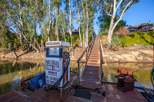 Moama,  Australia - October 3, 2019: Old rusty fuel pump for boats on decaying pier at Murray River