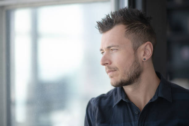 istock Young Man Reflecting Out a Window stock photo 1185783141