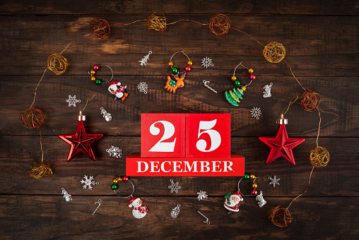 December 25th - Christmas Day concept depicted with the date and decorations arranged on rustic wood - top view
