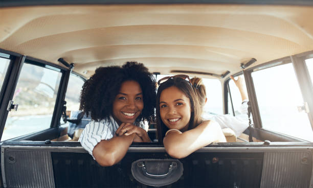 We've got dibs on the back seat Shot of two happy young friends going on a road trip together dibs stock pictures, royalty-free photos & images