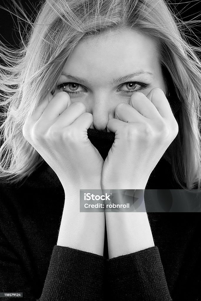 Mädchen erstreckt sich auf Ihren Gaumen mit einem schwarzen Rollkragenpullover - Lizenzfrei Attraktive Frau Stock-Foto