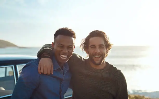 Shot of two happy young friends enjoying a vacation along the coast