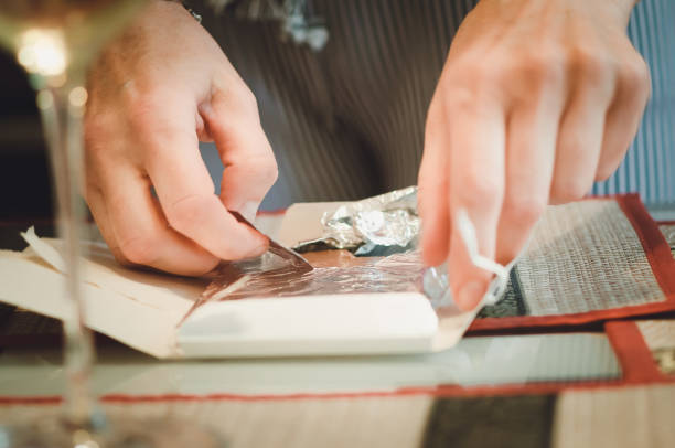 istock A man unfolds a chocolate, hands close up. 1185793919