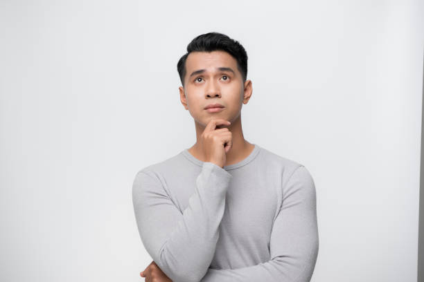 istock Studio shot of young Asian man thinking 1185795596