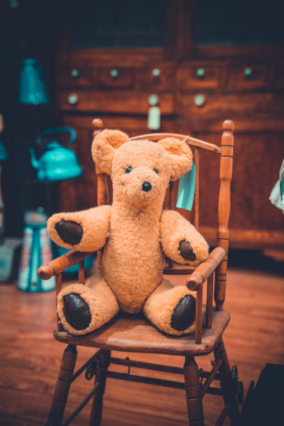 istock Old vintage style teddy bear in a child's seat 1185798590