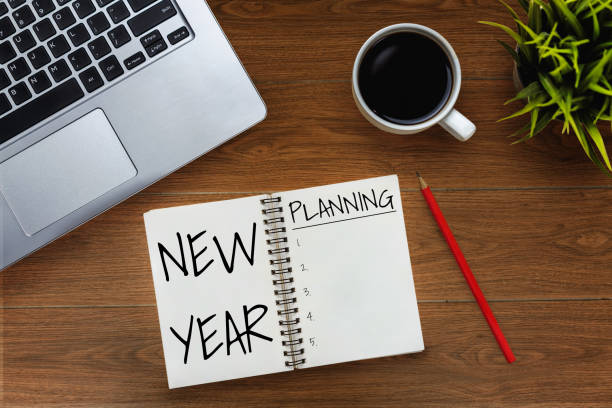 New Year Resolution Goal List 2020 - Business office desk with notebook written in handwriting about plan listing of new year goals and resolutions setting. stock photo