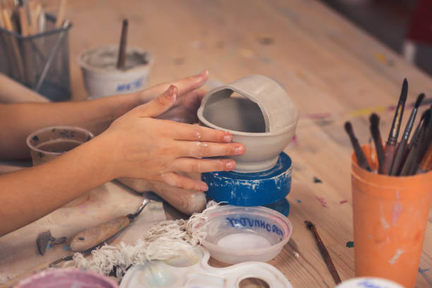 istock Children's hands sculpts from clay in art school. Close-up. 1185807311