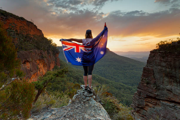 bandera patriótica de una mujer australiana cubierta a su alrededor en la escena de las montañas - australia australia day celebration flag fotografías e imágenes de stock