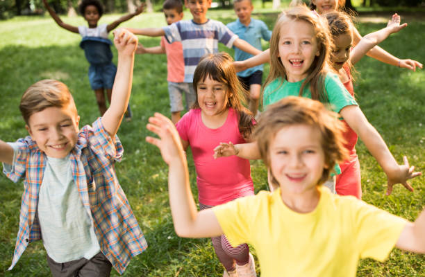 istock Group of happy kids having fun while running in spring day at the park. 1185811044