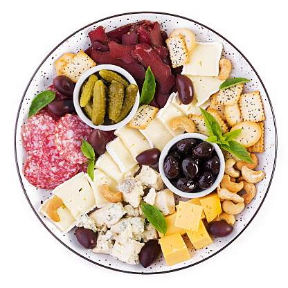 Antipasto platter with basturma, salami, blue cheese, nuts, pickles and olives on a isolated white  background. Top view, overhead