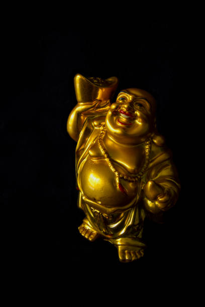 istock Gold color happy Buddha statue in black background 1185811498