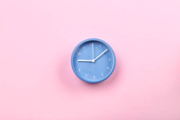 istock Blue round clock on pink background 1185811853