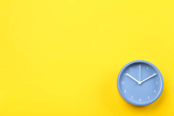 istock Blue round clock on yellow background 1185811875