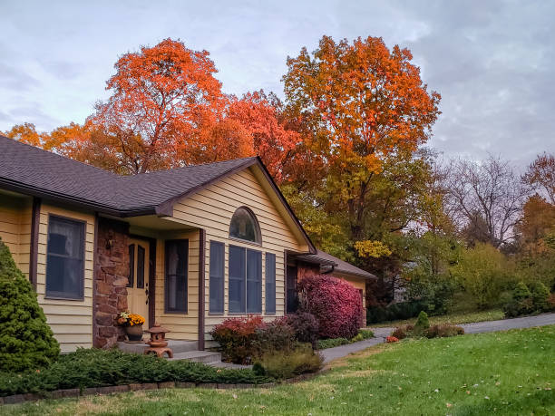 View of traditional Midwestern house in autumn View of traditional Midwestern house in fall; colorful trees and bushes in front and behind the house winged spindletree stock pictures, royalty-free photos & images