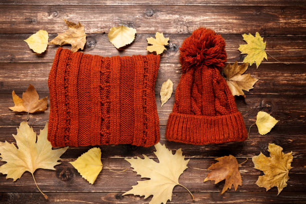 istock Woolen sweater with hat autumn leafs on brown wooden table 1185821041