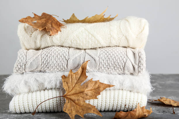 istock Folded sweaters with autumn leafs on gray background 1185823922