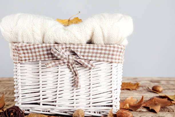 istock Folded sweater in basket with autumn leafs on gray background 1185824266
