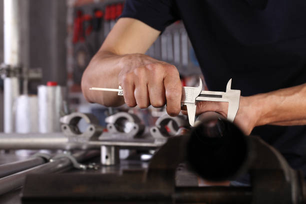 hände mann nahaufnahme arbeit in der hauswerkstatt garage mit sättel messen metallrohr an der sicht auf dem arbeitsplatz befestigt, diy und handwerk konzept - mikrometer feinmessgerät stock-fotos und bilder