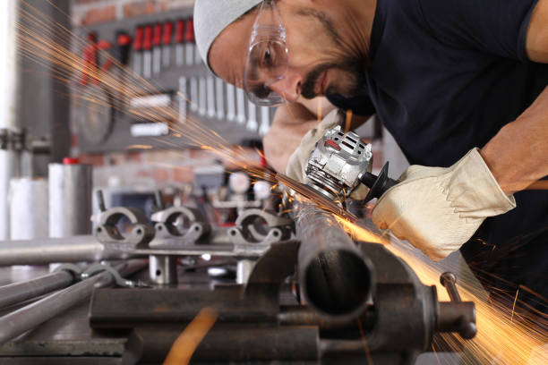 istock man work in home workshop garage with angle grinder, goggles and construction gloves, sanding metal makes sparks closeup, diy and craft concept 1185835541
