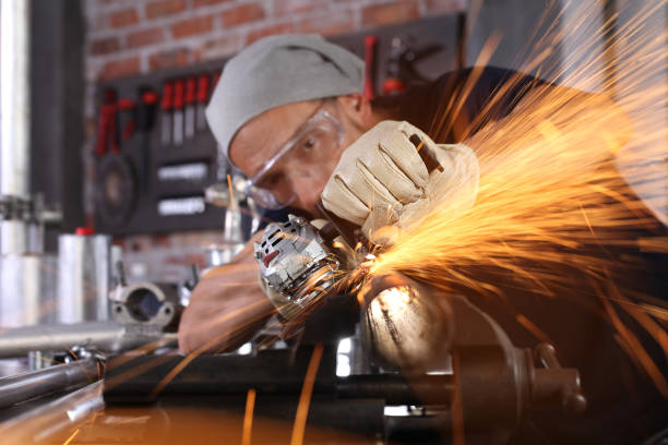 istock man work in home workshop garage with angle grinder, goggles and construction gloves, sanding metal makes sparks closeup, diy and craft concept 1185835568