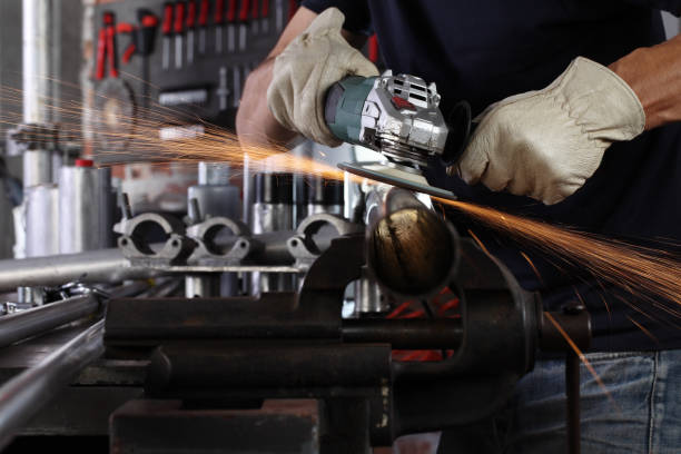 istock hands man work in home workshop garage with angle grinder, goggles and construction gloves, sanding metal makes sparks closeup, diy and craft concept 1185835569