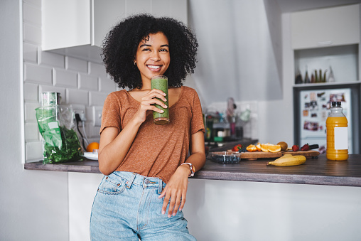 Shot of a young woman enjoying a healthy smoothie at home