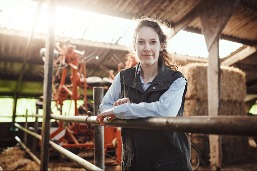 Shot of a confident young woman working at a dairy farm