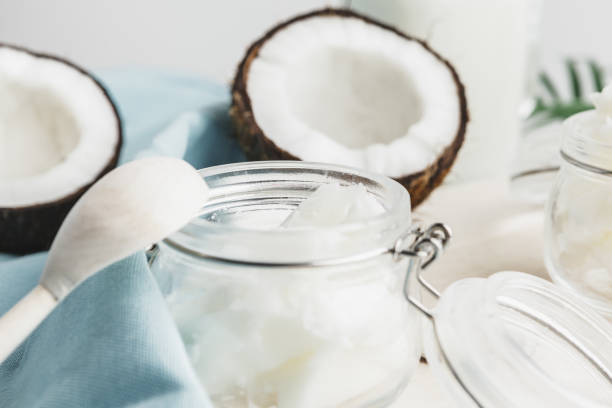 organiczne zdrowe masło kokosowe i świeże kawałki kokosa na drewnianej desce - cold pressed zdjęcia i obrazy z banku zdjęć