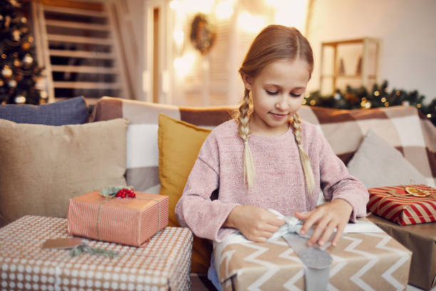 istock Little girl opening present 1185847481