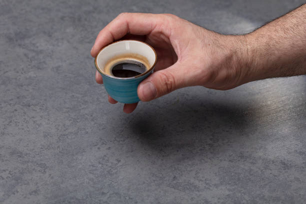 A Men holding Espresso coffee on background