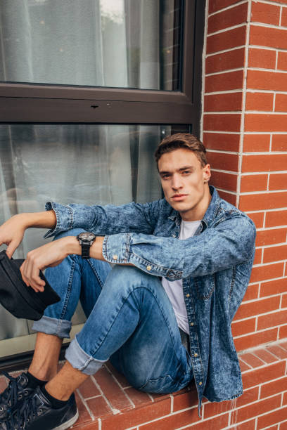 istock Handsome young man sitting by the window 1185849629