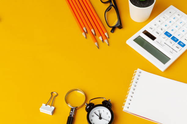 istock Stylish messy yellow desk top with various stationery top view 1185849885