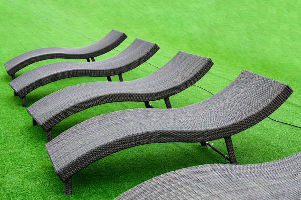 istock Modern black loungers on artificial lawn on poolside 1185851318