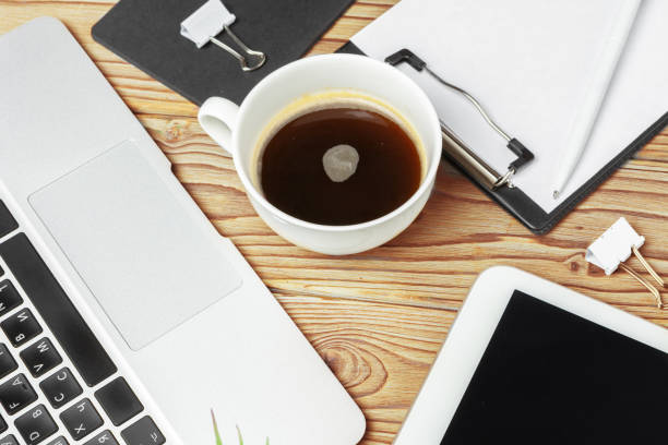 istock Wooden office desk table and equipment for working with black coffee in angle view 1185851496