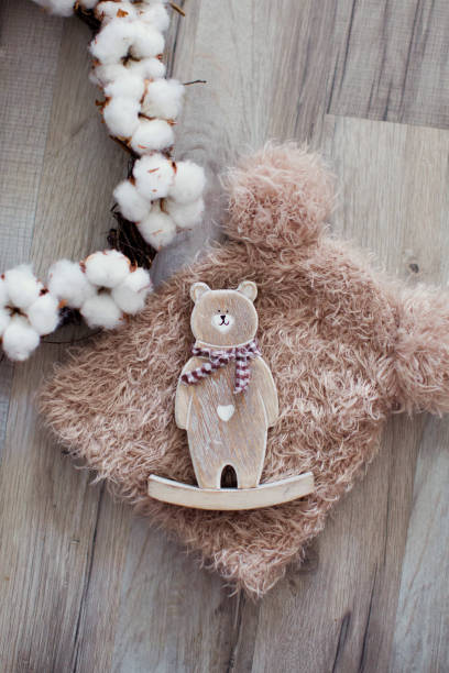 set of knit teddy bear hat, wreath oof cottons and wooden bear - oof imagens e fotografias de stock