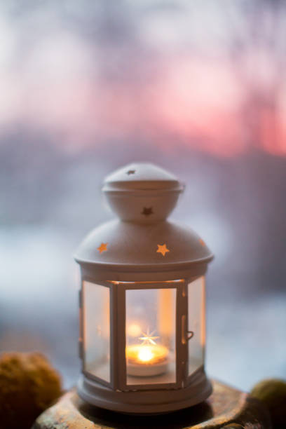 istock white lantern with candle at sunset pink sky 1185854044